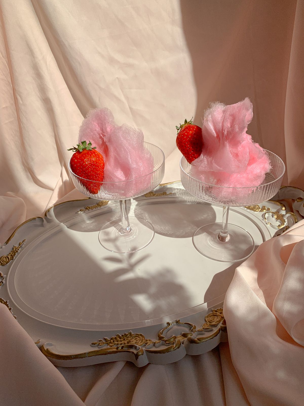 Pink cotton candy with strawberries on a tray