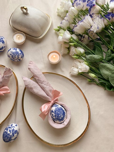 Chic Easter table arrangement with floral painted eggs and white flowers for a festive decor.