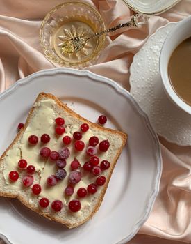 An appetizing breakfast setup with buttered toast topped with berries, accompanied by coffee.