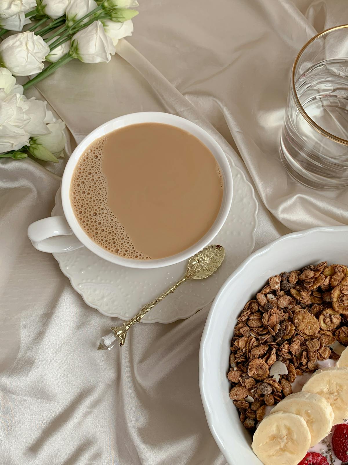 Person assembling a snack plate with vegetables, dips, and bread on a wooden board