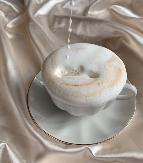 Coffee with Foam in White Porcelain Cup and Saucer