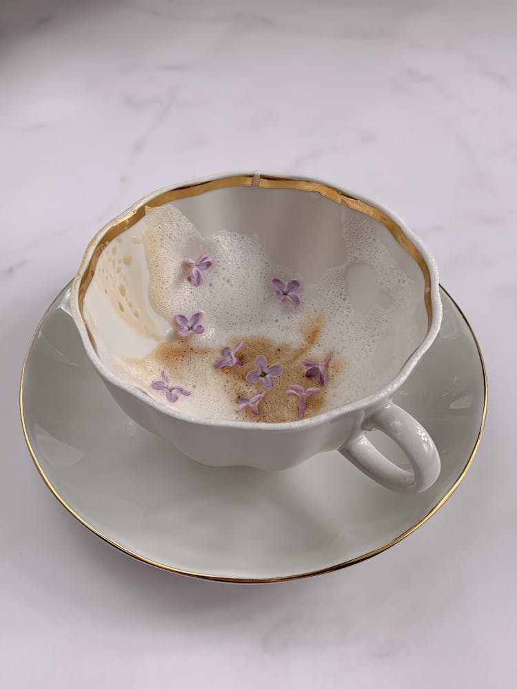 Purple Flowers In White Cup With Coffee Foam