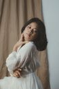 Girl in White Long Sleeve Dress Holding Hand Beside Face
