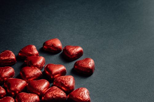 Free Heart-shaped red chocolates on a gray surface, perfect for romantic themes. Stock Photo