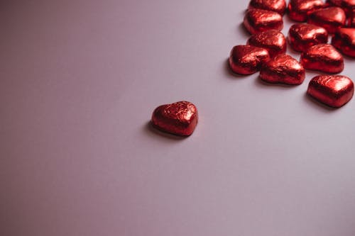 Red Heart Shaped Sweets on Pink Surface