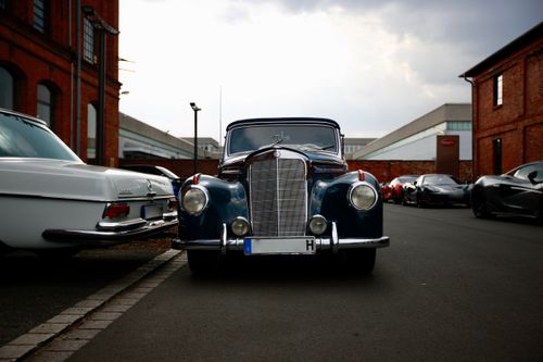 Free A classic vintage car parked on a city street surrounded by other luxury vehicles. Stock Photo