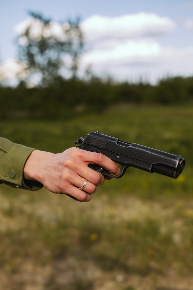 A Person Holding A Pistol