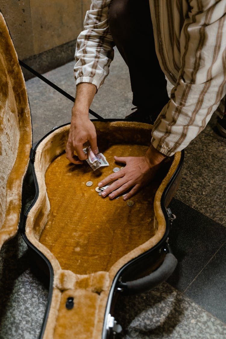 Man Removing The Money In His Guitar Case