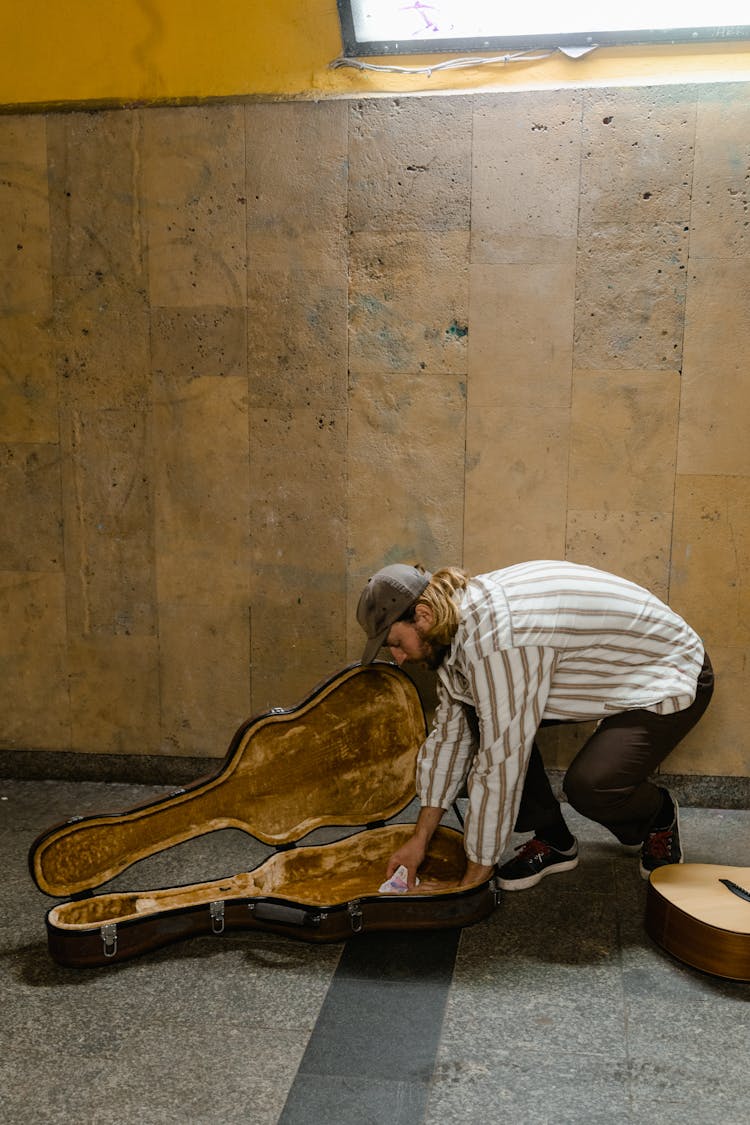 Man Removing The Money In His Guitar Case