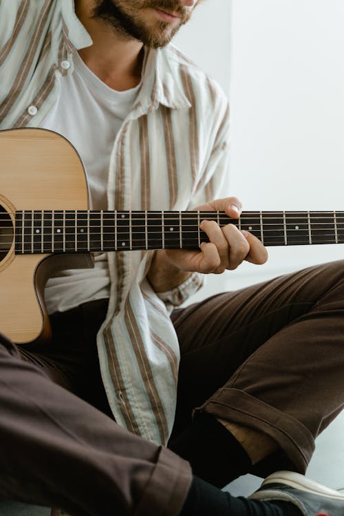 Man in White and Brown Stripe Dress Shirt Playing Brown Acoustic Guitar
