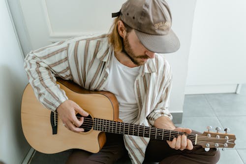 Man in White and Brown Stripe Dress Shirt Playing Brown Acoustic Guitar