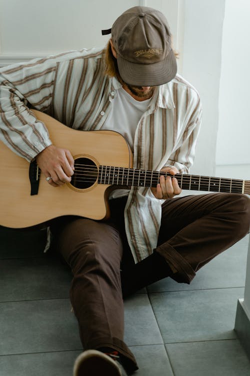 Man in White and Brown Stripe Dress Shirt Playing Brown Acoustic Guitar