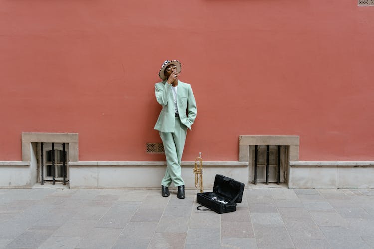 Man Leaning On Red Wall