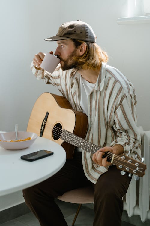 adam, akıllı telefon, akustik gitar içeren Ücretsiz stok fotoğraf