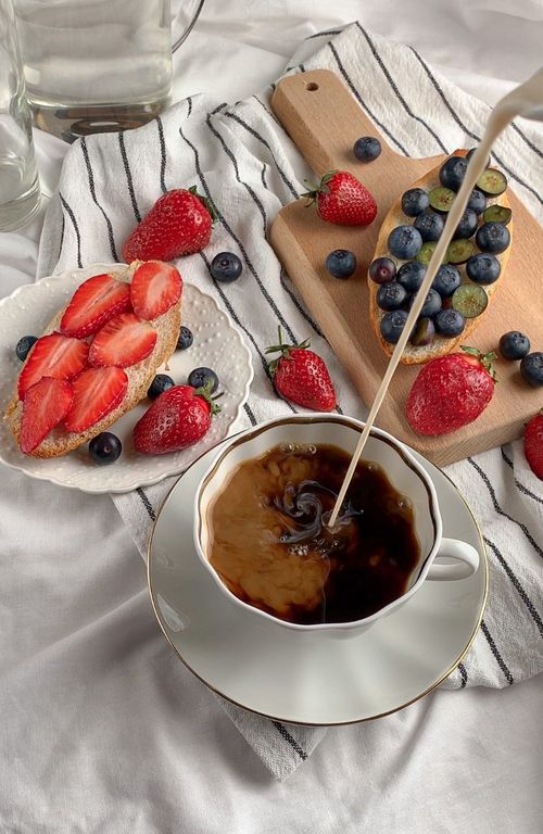 Free A delicious breakfast scene with strawberries, blueberries, and steaming coffee. Stock Photo