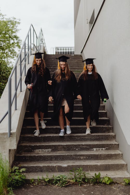 Women Wearing Graduation Hats Going Down the Stairs