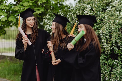 Free Women Wearing Graduation Hats Holding Diplomas Stock Photo