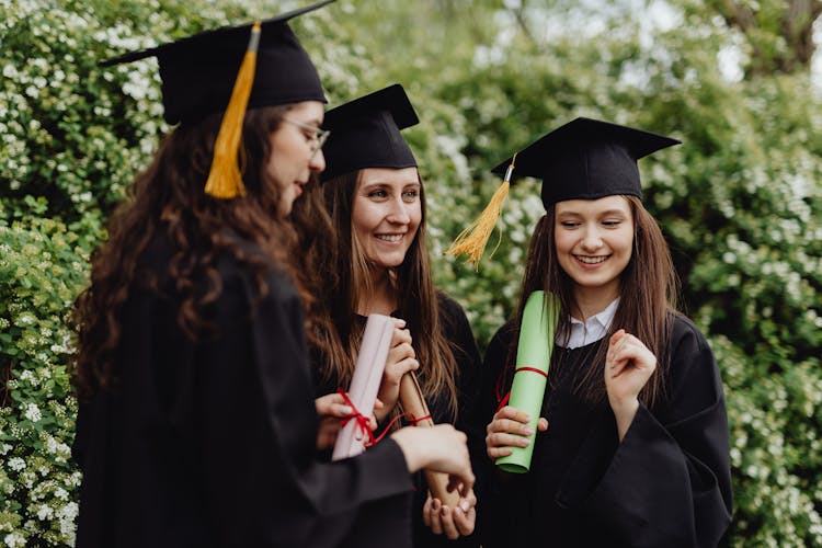 Young Girls Holding Their Diplomas