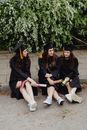 2 Women Wearing Academic Dress and Mortar Board