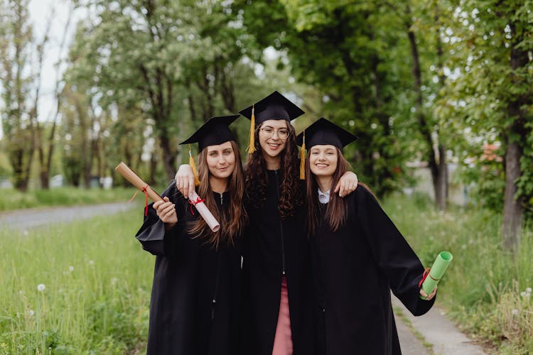 Happy Women Wearing Graduation Caps