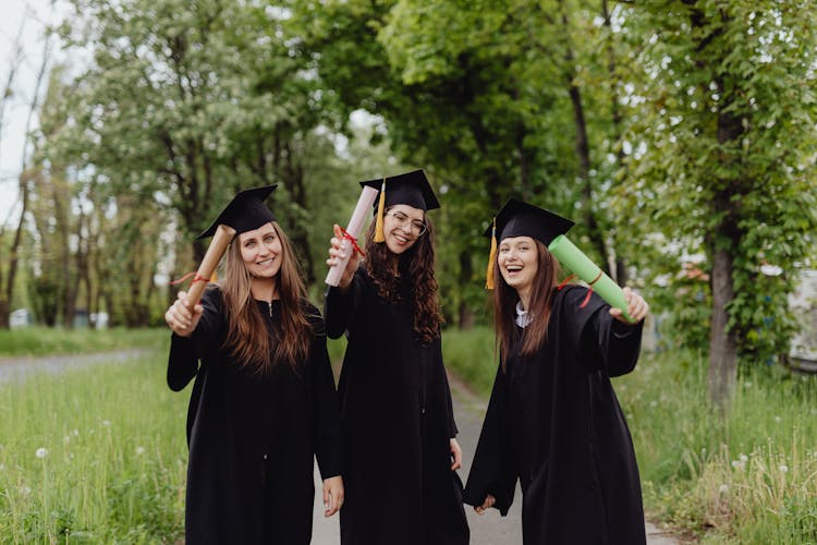 Young Graduates Holding Their Diplomas