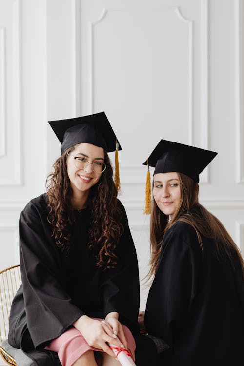 Free Women Sitting Wearing Academic Dress  Stock Photo