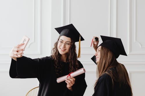 Free Women Taking Photos Wearing their Academic Dress  Stock Photo