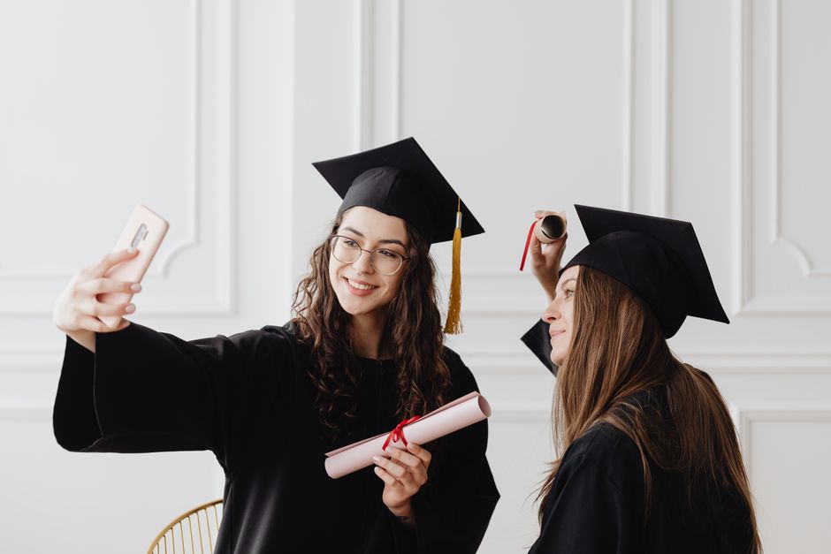 Graduates taking photos representing student loan types and repayment differences