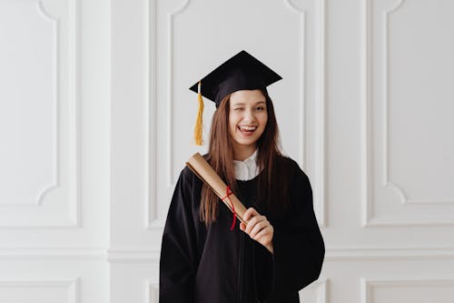 Free Woman in Academic Dress Smiling with her Tongue Out Stock Photo