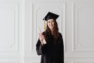 Woman in Black Academic Dress Standing and Smiling