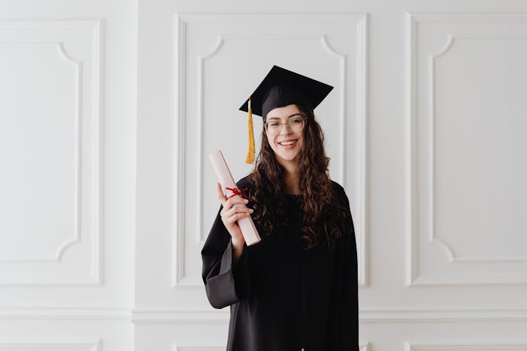 A Woman Wearing A Graduation Cap And Gown