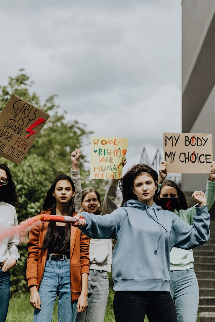 Young Women Activists Holding Posters 