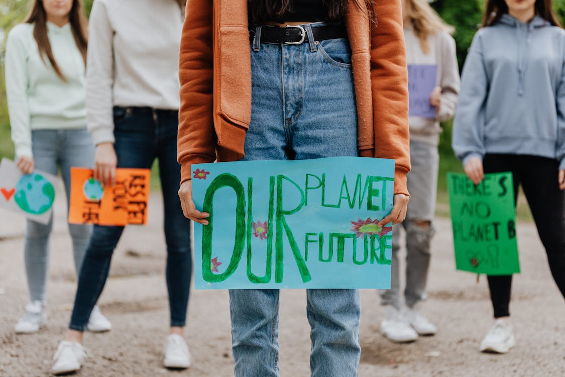 Photo of protesters holding protest signs protesting inaction on climate change