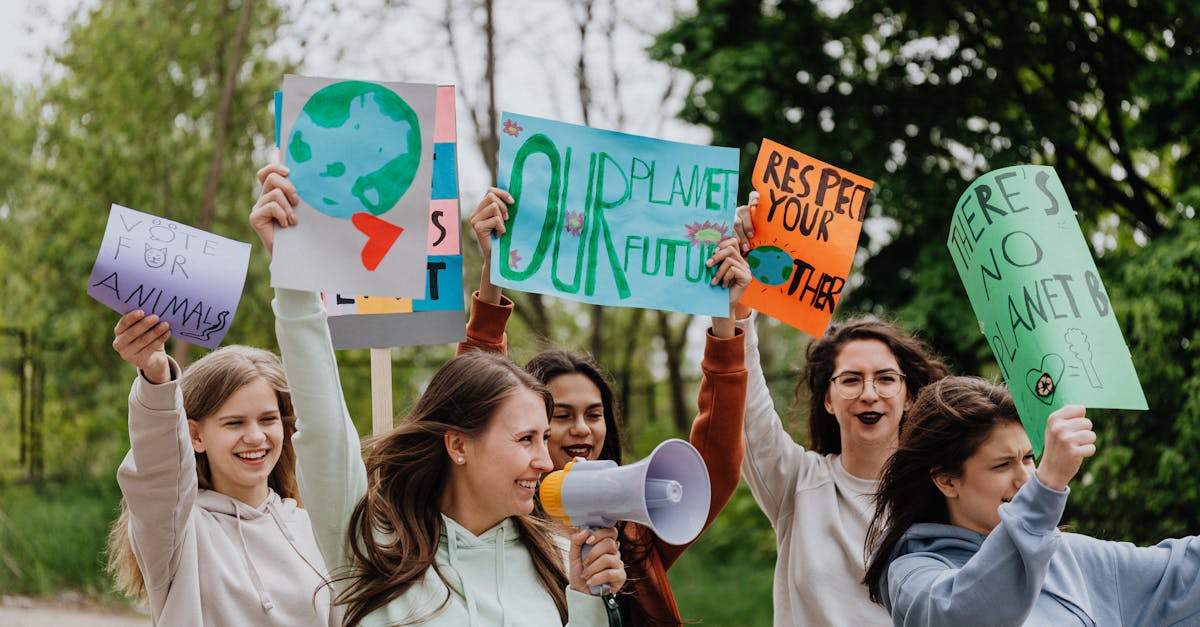 Group of young activists holding placards and megaphone during an outdoor environmental protest.