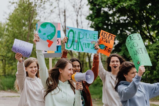Group of young activists holding placards and megaphone during an outdoor environmental protest.