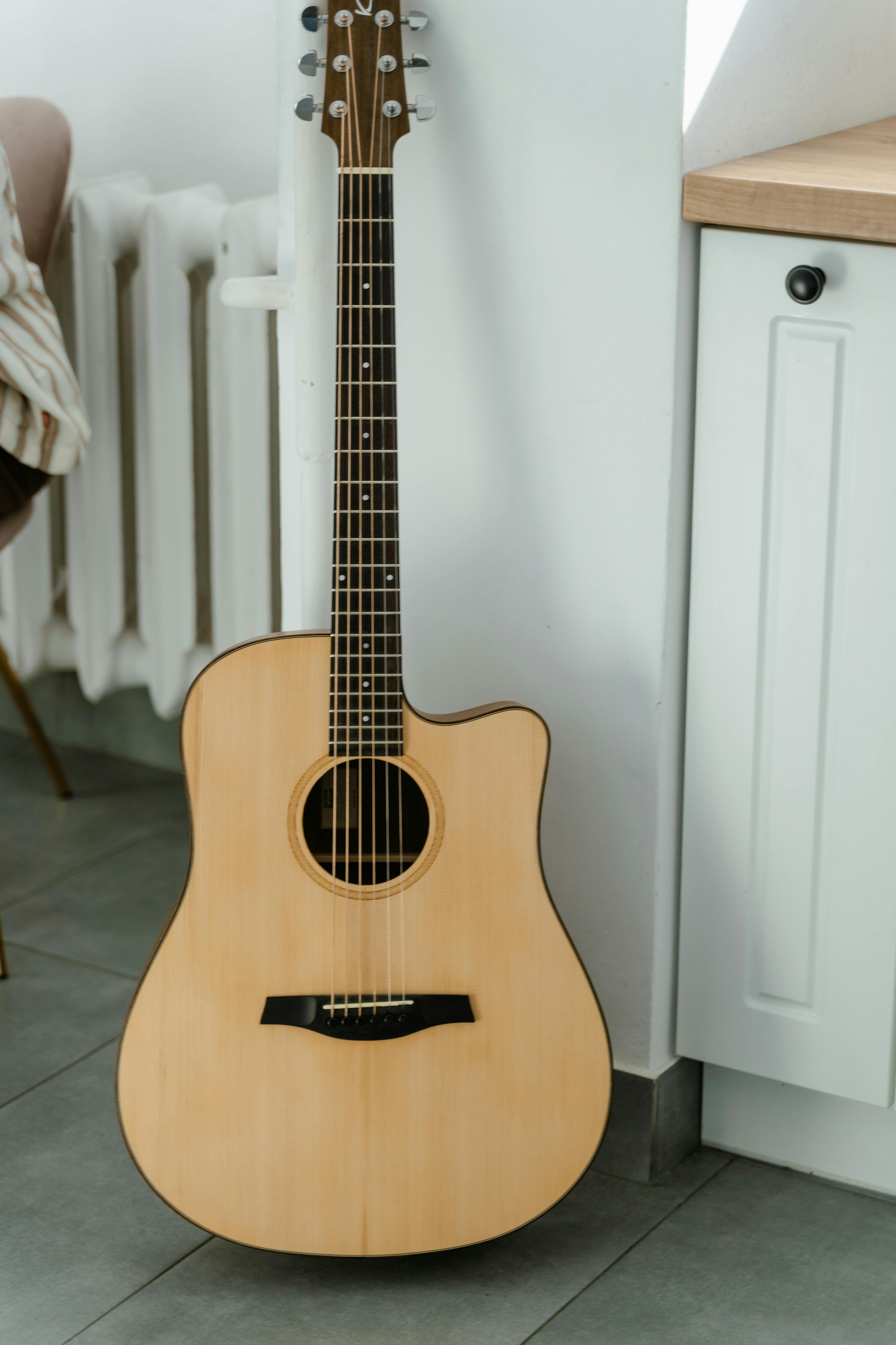 Brown Acoustic Guitar on White Wall · Free Stock Photo