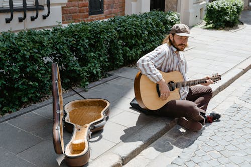 Man in Brown and White Stripes Dress Shirt Playing Brown Acoustic Guitar