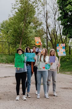 Group of young women holding protest signs advocating for environmental action outdoors.