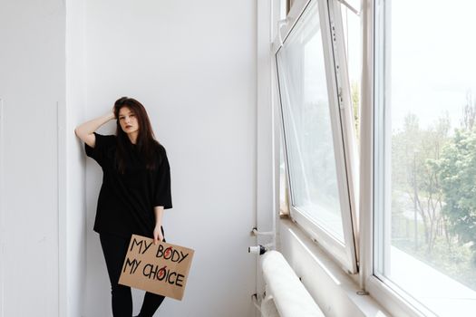 Woman in Black Shirt Standing Beside Window