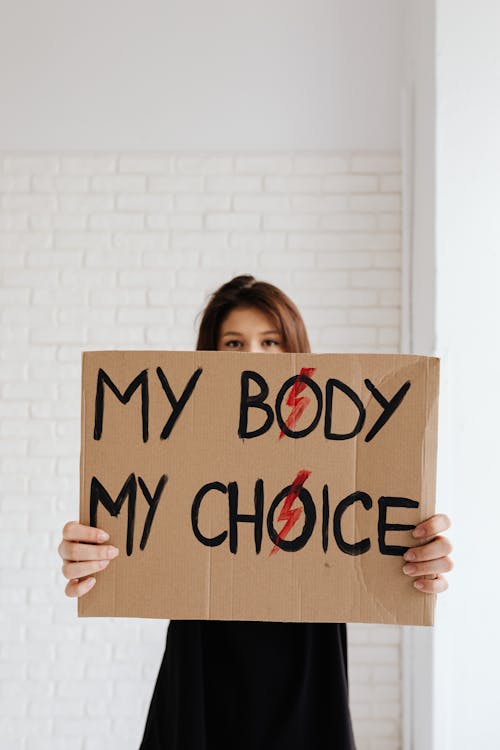 Free Woman Holding a Cardboard Poster Stock Photo