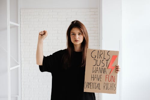 Free Woman in Black Crew Neck Shirt Holding a Cardboard Stock Photo