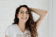 一位戴着眼镜和纹身、穿着白色衬衫的年轻女子的肖像