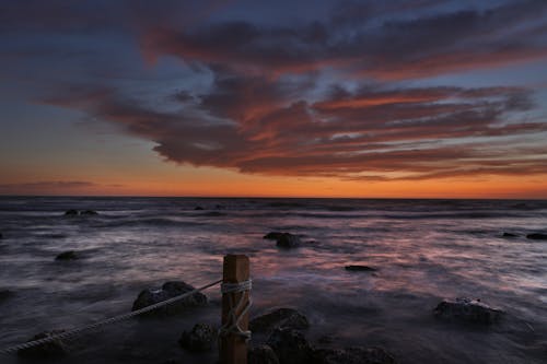 Ocean Waves Crashing on Rocks during Sunset