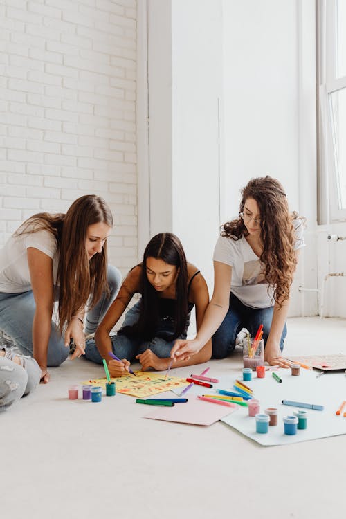 Young Women Sitting on the Floor and Painting 