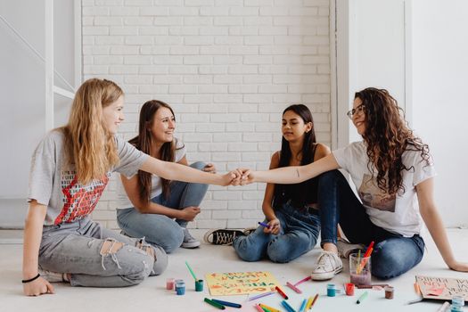 A group of teenage girls engaging in a creative art session, promoting teamwork and friendship.
