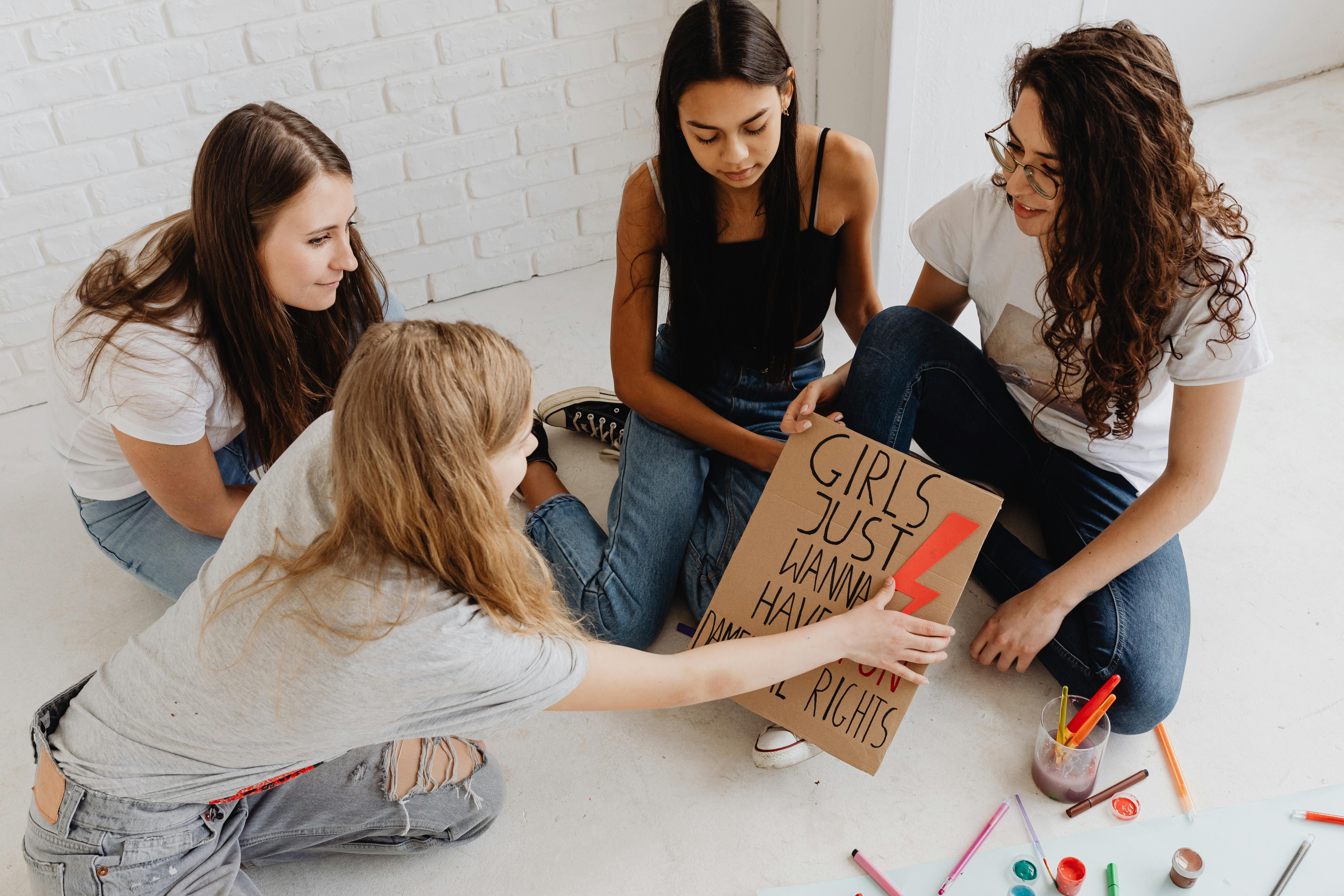 Women Sitting On The Floor While Writing On A Cardboard · Free Stock Photo