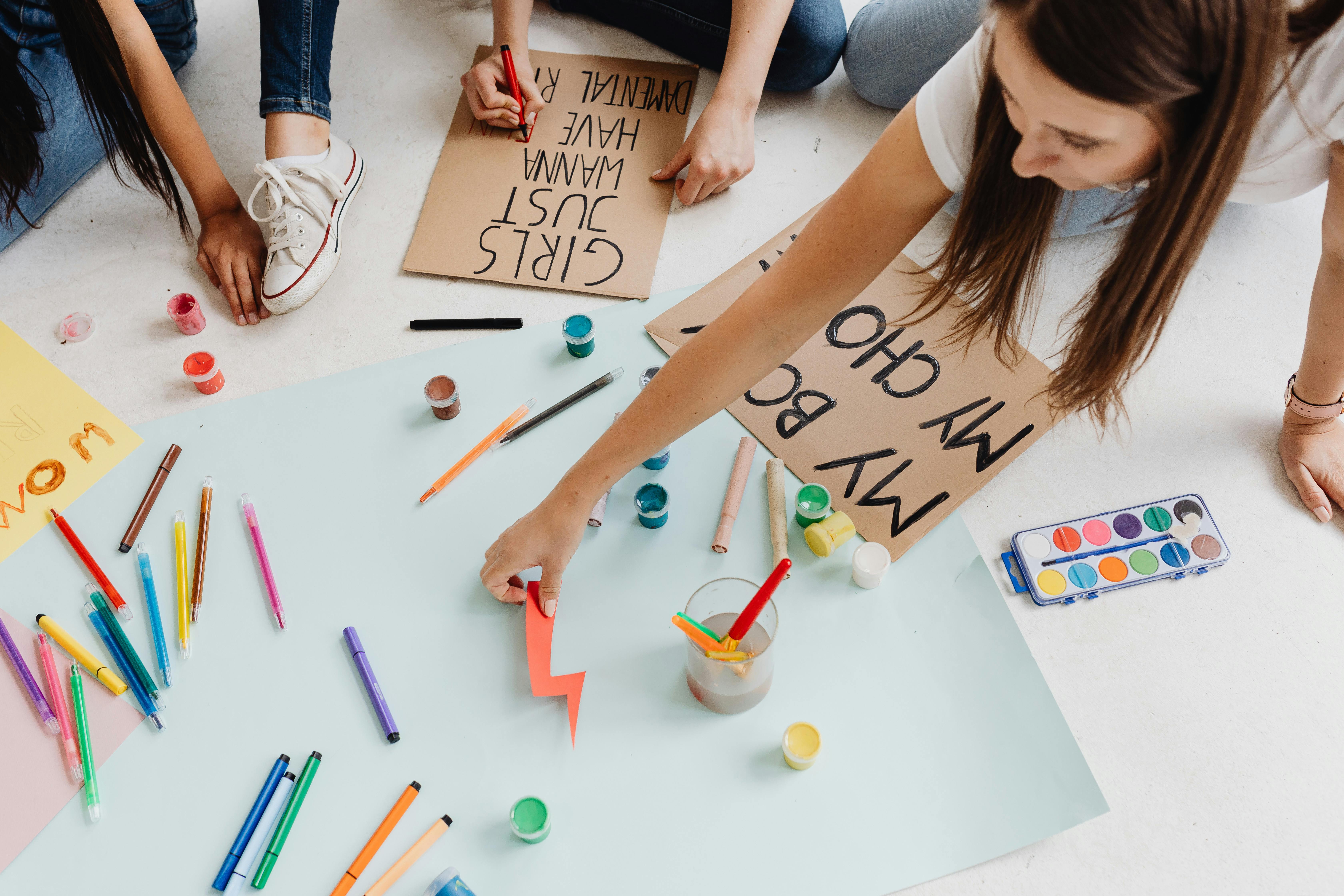 two women writing on cardboards