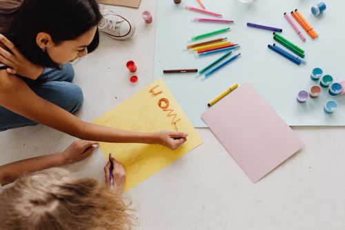 Free Women sitting on the floor creating an activism poster with art supplies. Stock Photo