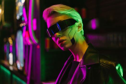 Stylish woman in cyberpunk glasses with neon lights and futuristic makeup.