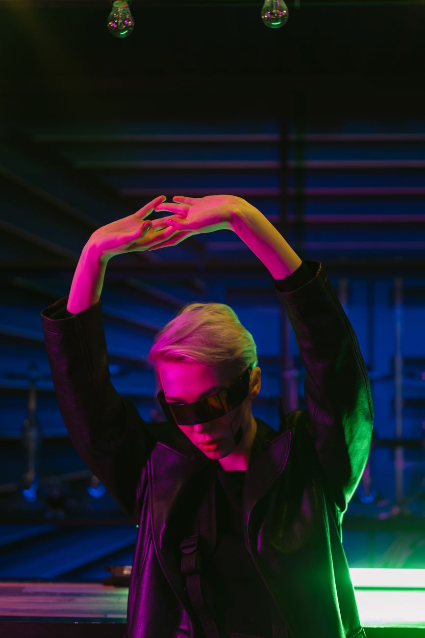 A stylish portrait of a woman in sunglasses and neon lighting, exuding a cool and futuristic vibe.